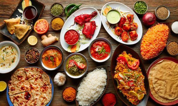 Assorted Indian recipes food various with spices and rice on wooden table