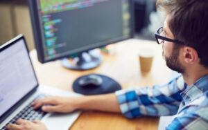 Close up shot of a young software developer working hard at his desk