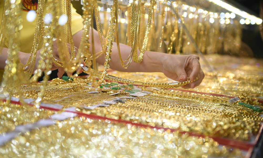 Nhân viên tiệm vàng chọn lựa sản phẩm theo ý khách.