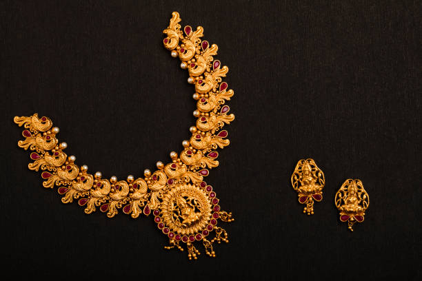 Traditional Indian Gold Necklace With Earrings on black background.